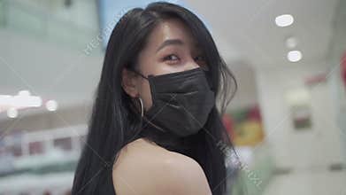 SLOW MOTION smile under face mask of Young attractive Asian woman While walking inside grocery supermarket store during covid-19 c