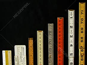 Vertical row of old rulers suggests a graph of increasing growth