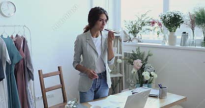 Happy young fashion designer using virtual assistant application.