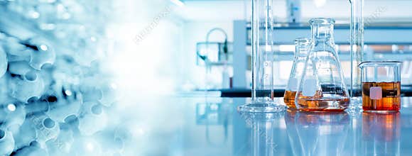 Beaker and flask in science laboratory with chemical structure blue banner background