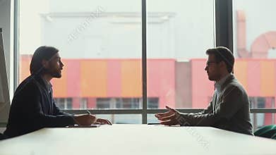 Two businessmen negotiators wear suits shake hands after successful negotiations