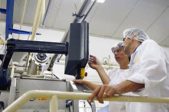 Factory workers operating the control panel