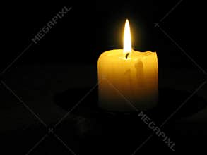 Yellow candle in a dark room
