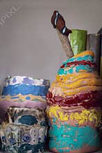 Childrens clay projects sitting on shelf with books - selective focus