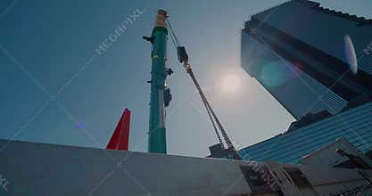 Belarus, Minsk - July 30, 2020: Mobile truck crane boom with chains on sky background. Lens flare