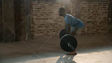 Sport man using chalk powder on hands and lifting weights at gym