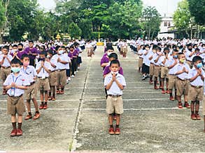 Trang, Thailand - July 31, 2020 : Students from Banyantakhao school wear surgical face mask to protect covid-19 and praying after