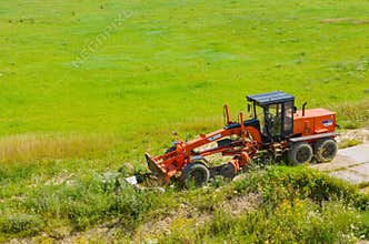 agrimotor on green field and blue sky