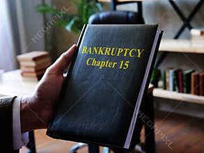A lawyer shows a book on bankruptcy chapter 15.