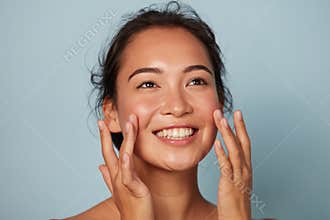 Beauty face. Smiling asian woman touching healthy skin portrait