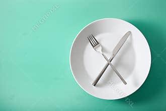 Concept of intermittent fasting and ketogenic diet, weight loss. fork and knife crossed on a plate