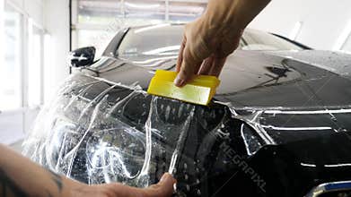 Close up to PPF installation process on a front rear headlight and bamper.