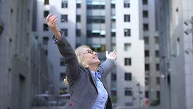 Optimistic elderly female turning around raising hands, enjoying life, vitality