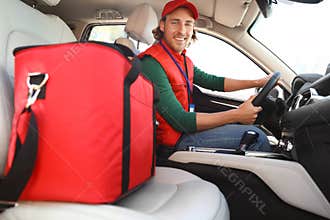 Male courier with thermo bag in car. Food delivery