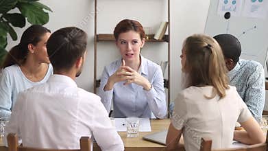 Diverse employees sitting around the table listening teacher receiving knowledge