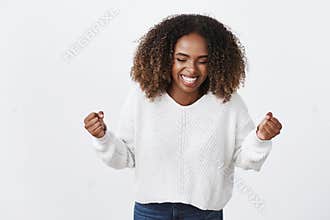 Yes finally ahievement. Portrait charming african-american smiling happy woman clench fists victory gesture triumphing