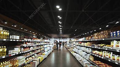 Wide and long aisle in a grocery shop, people shopping
