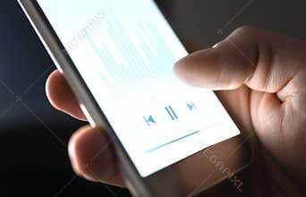 Listening to podcast, music or audiobook with mobile phone. Man using streaming service and smartphone app with audio player.