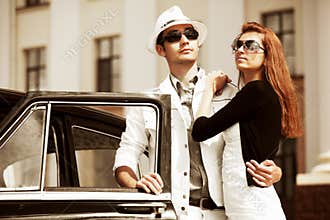 Young fashion couple in love next to retro car