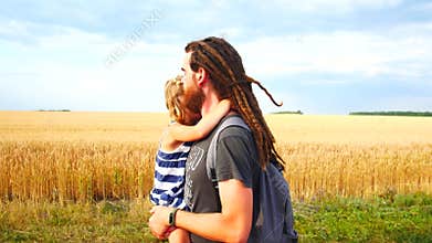 Dad carries daughter in his arms. Walk in the countryside.
