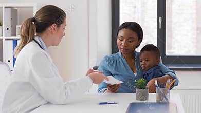 Happy mother with baby son and doctor at clinic