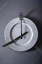 Concept of intermittent fasting and ketogenic diet, weight loss. fork and knife crossed on a plate