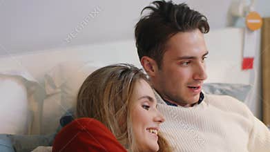 Guy and girl lie on comfortable bed choosing home furniture