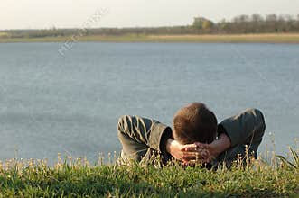 Dreaming man on the river bank