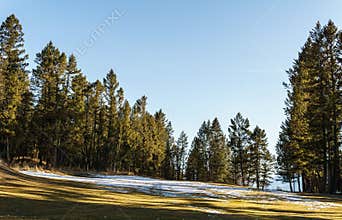 FAIRMONT HOT SPRINGS, CANADA - MARCH 22, 2019: Golf Course field in small town in rocky mountains sunny afternoon