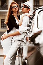 Young fashion couple in love next to vintage car