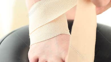 Man wraps foot in elastic bandage