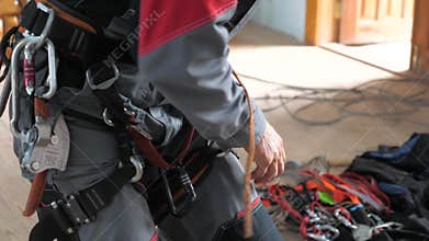 Industrial climber puts on equipment for high-altitude work. on the climber s belt carabiners.