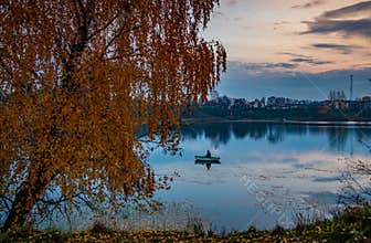 Lake landscape at fall, fishing in a boat
