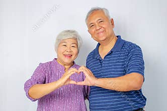 Relationships, love and old people concept -  Happy seniors couple showing hand heart gesture and smiling