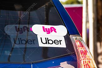 Oct 10, 2019 Mountain View / CA / USA - Lyft and UBER stickers on the rear window of a vehicle offering rides in San Francisco Bay