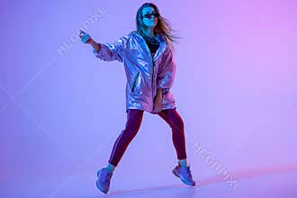 Young stylish girl dancing in the Studio on a colored neon background. Music dj poster design.