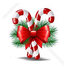 Christmas candy canes with red bow isolated on white.
