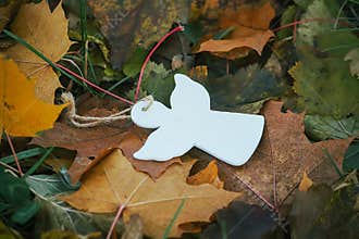 Wooden decoration angel white figure on fall leaves background