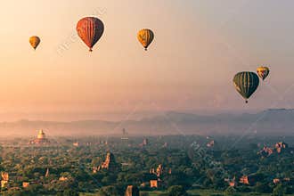 Many hot air balloons flying over the temples