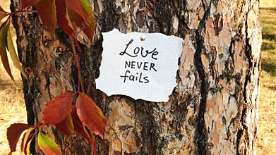 Love never fails - card with biblical quote, christian lettering on card