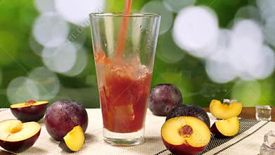 Plum Juice Poured into Glass with Ice Cubes