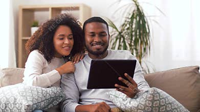 Couple having video call on tablet pc at home
