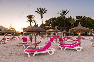Sunbeds with umbrellas at the Playa de Alcudia beach in Mallorca, Spain