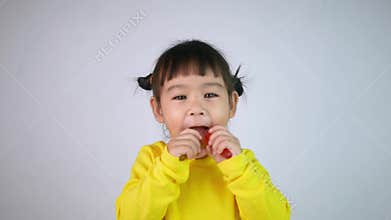Portrait of a happy smiling Asian child girl and enjoy eating gelatin dessert isolated on white background.