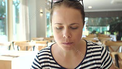 A woman is having Breakfast in the hotel restaurant, she is eating grilled toast