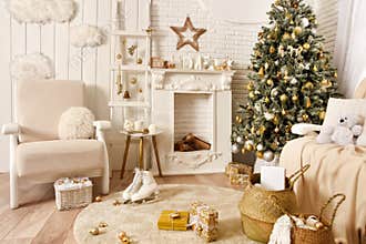 White Christmas interior. Beautiful Christmas tree, armchair, baskets, gifts, skates, stairs and other decoration