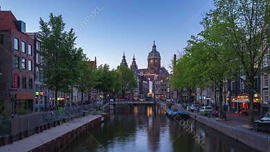Amsterdam canal and skyline at night with Saint Nicholas Church time lapse in Amsterdam city, Netherlands