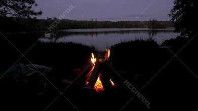 Fire camp beside a lake at night