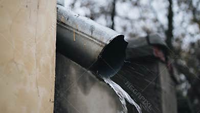 Water rapidly flies out of the drainpipe during the rain. Close up. Bad weather.