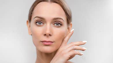 Close-up face naked sexy European blonde woman with perfect skin stroking chin isolated